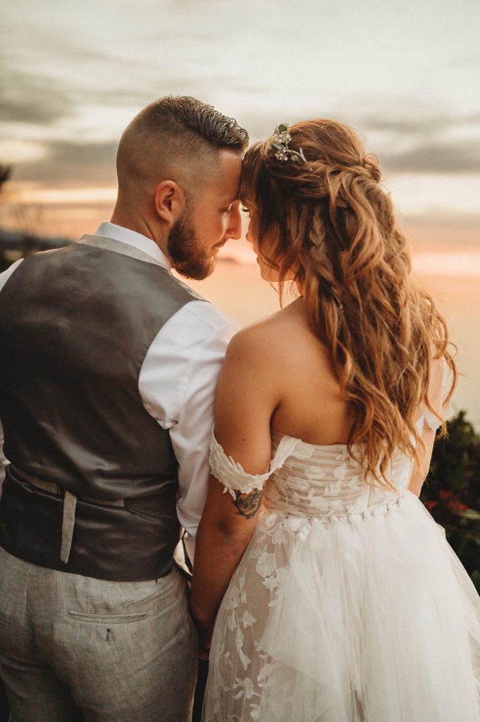 Bride and groom close romantic moment at sunset wedding Events by Aubrie